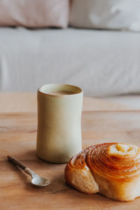 Close-up of coffee cup on table with croissant 