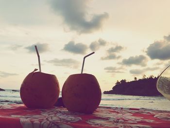 Close-up of fruits on table against sky during sunset