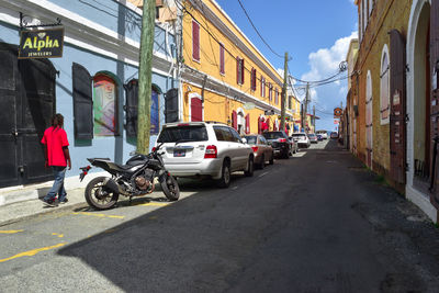 Cars on road by buildings in city