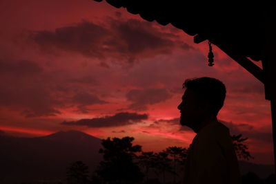 Silhouette man standing against orange sky