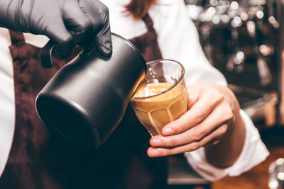 Midsection of woman pouring wine in glass