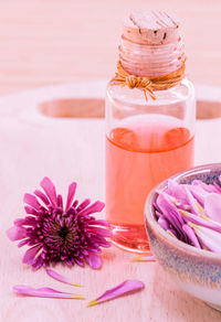 Close-up of essential oil and flower on table