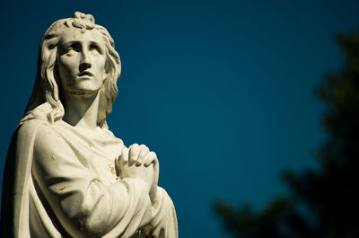 Low angle view of statue against clear blue sky