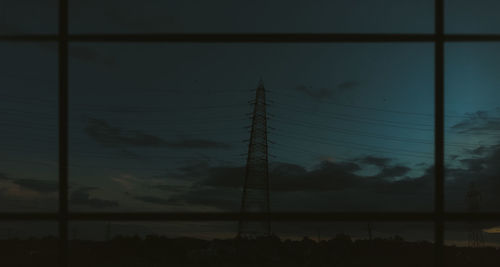 Low angle view of silhouette electricity pylon against sky at sunset