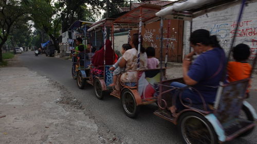 Rear view of people walking on road in city