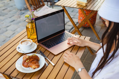 Midsection of woman using laptop on table