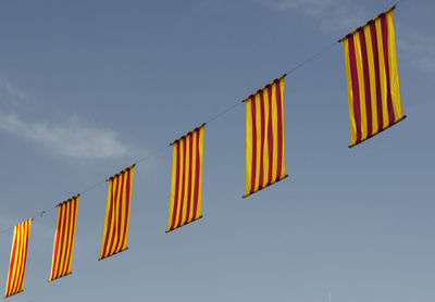 Low angle view of flags hanging against sky