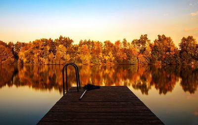 Pier amidst lake against sky during autumn