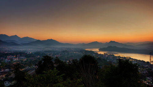 High angle view of trees and mountains against sky during sunset