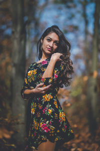 Young woman looking away while standing outdoors