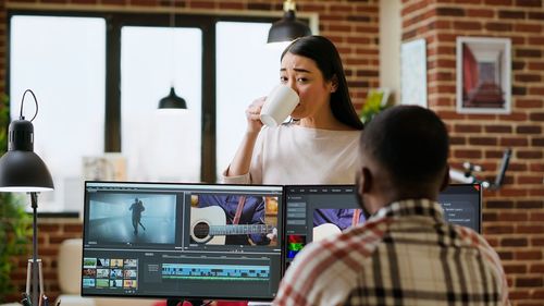 Side view of woman using laptop at office