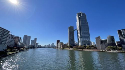 Sea by modern buildings against clear sky