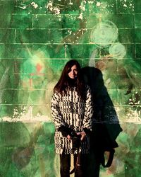 Woman standing against graffiti wall