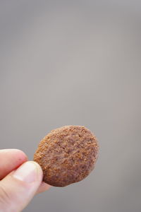 Close-up of hand holding ice cream over white background