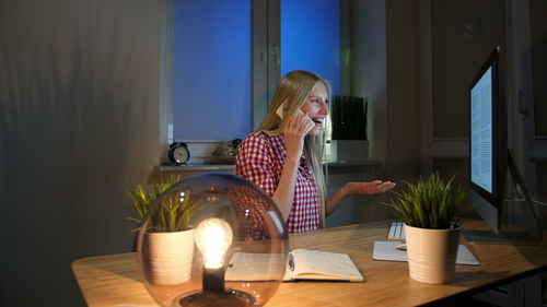 Woman sitting on table at home