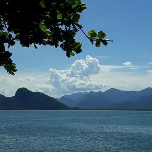 Scenic view of sea and mountains against sky