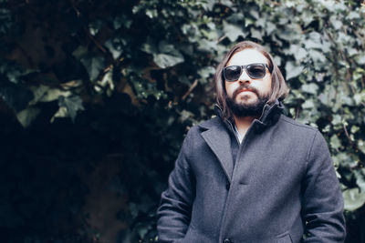 Portrait of man standing against plants