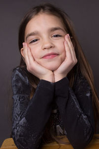 Portrait of smiling girl against black background