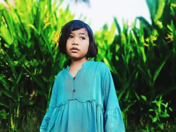 Portrait of girl standing against plants