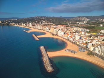 Aerial view of sea and buildings against sky