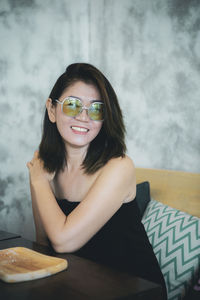 Portrait of smiling woman sitting on table