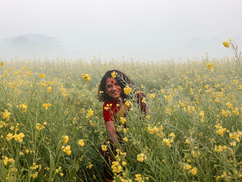 Portrait of young woman standing on field