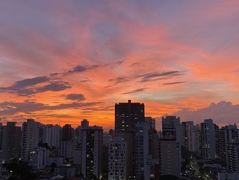 Modern buildings against sky during sunset