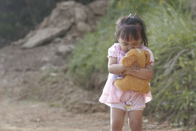 Girl embracing stuffed toy