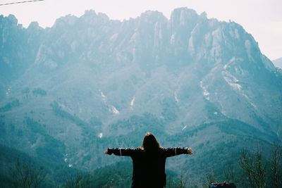 Woman standing on mountain against sky