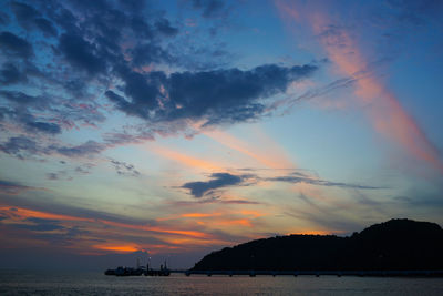 Scenic view of sea against cloudy sky during sunset