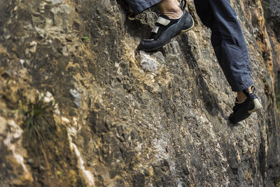 Low section of man climbing on rock