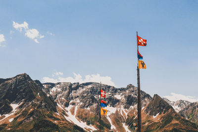 Information sign on snowcapped mountain against sky