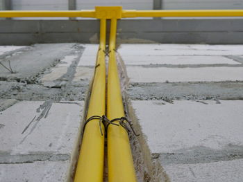 Yellow pvc electrical conduits or pipes are installed in and above house wall for power and lighting