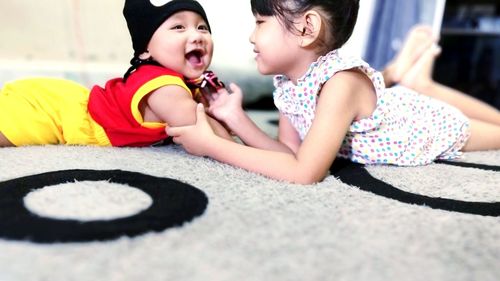 Cute girl sitting on woman looking away