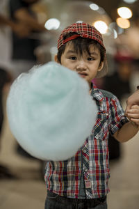 Portrait of cute boy holding cotton candy