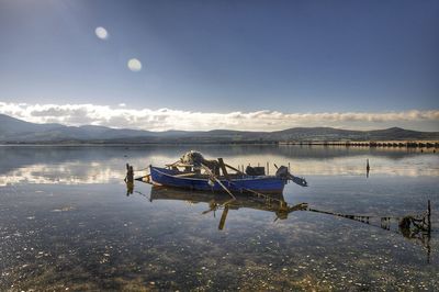 Boat moored on shore against sky