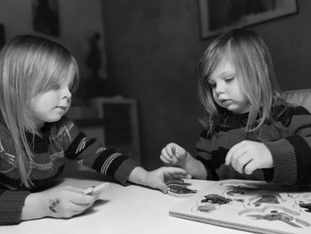 Happy girls with puzzle on table