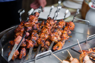 Close-up of barbecue meat in skewers on container