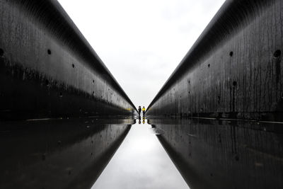 Footpath amidst water against sky
