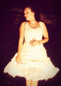Beautiful young woman standing against wall