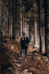 Full length of woman standing at forest