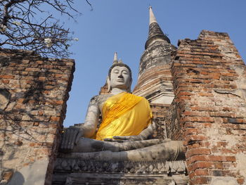 Low angle view of statue against historic building against sky