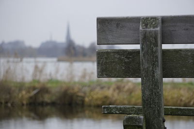 Close-up of cross on lake against sky