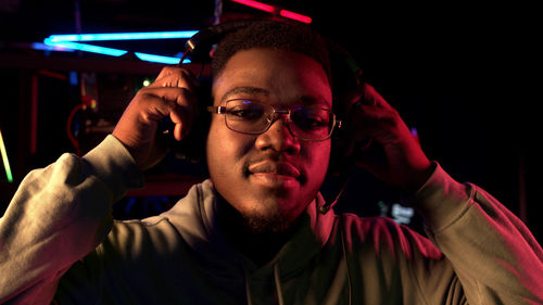 Portrait of young man standing in internet cafe