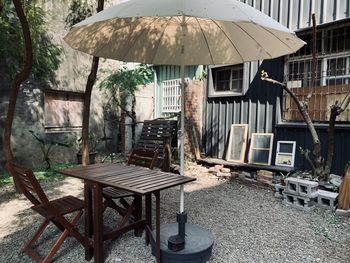 Empty chairs and tables in house against building