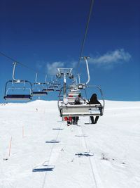 Ski lift on snowcapped mountain against sky