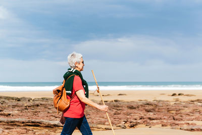 Man standing at beach against sky