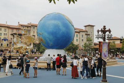 People on street against buildings in city