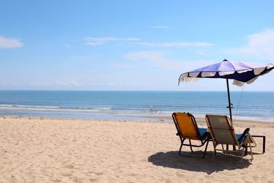 Bed beach and blue umbrella on tropical beach with blue sky in the summer morning.