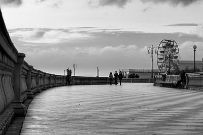 Men on bridge against sky